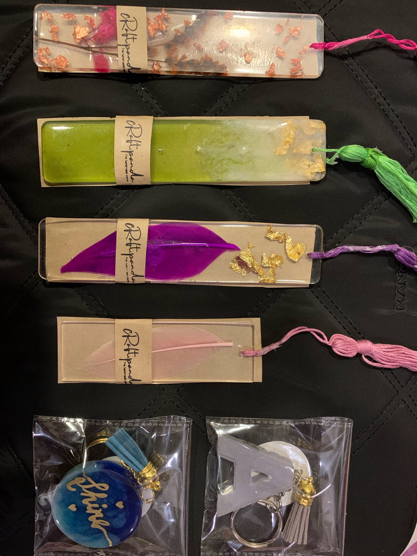 Collection of handmade resin bookmarks with feathers, gold flakes and tassels