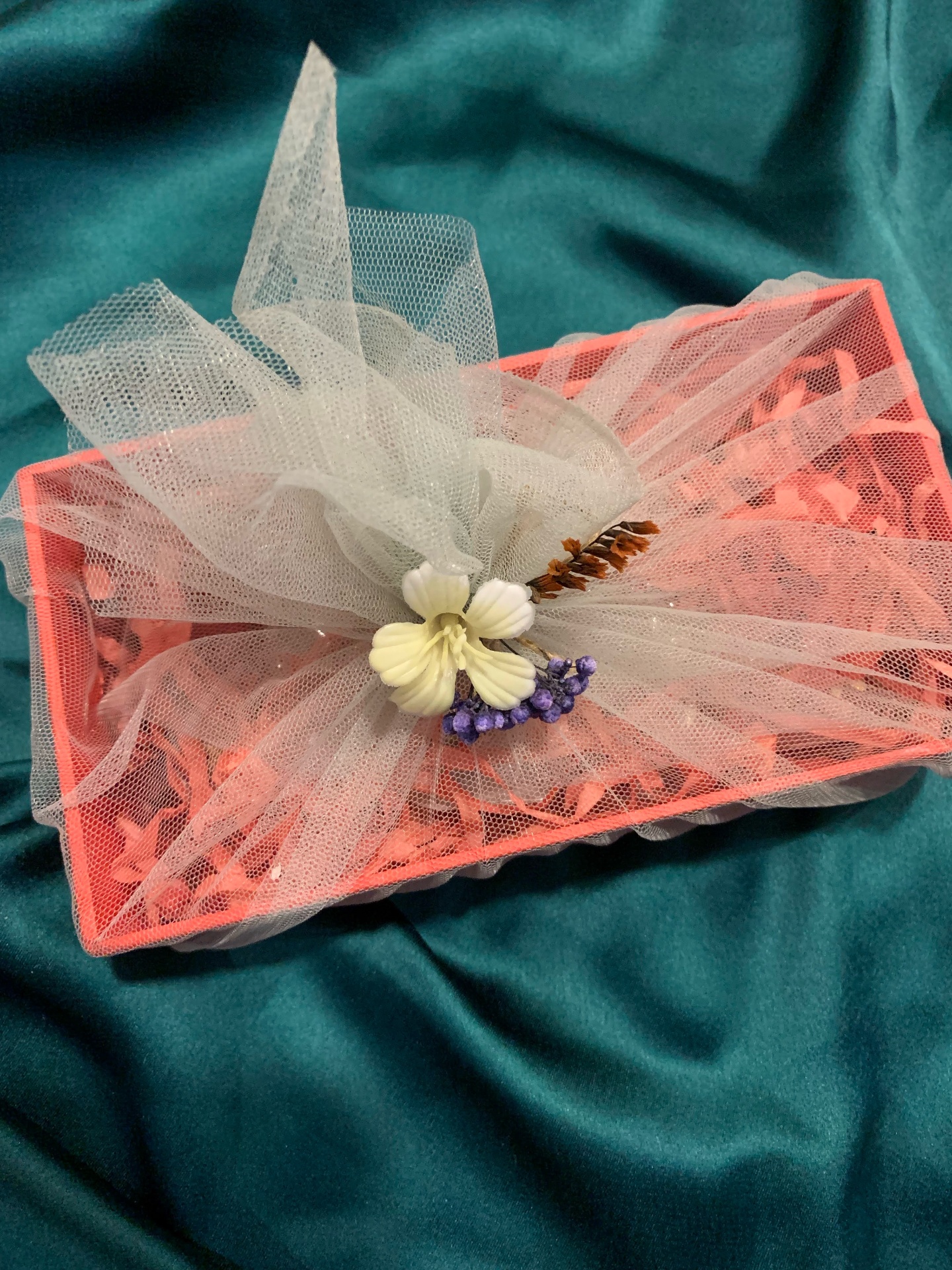 Coral crochet tray hamper wrapped in ivory tulle with a small flower posy