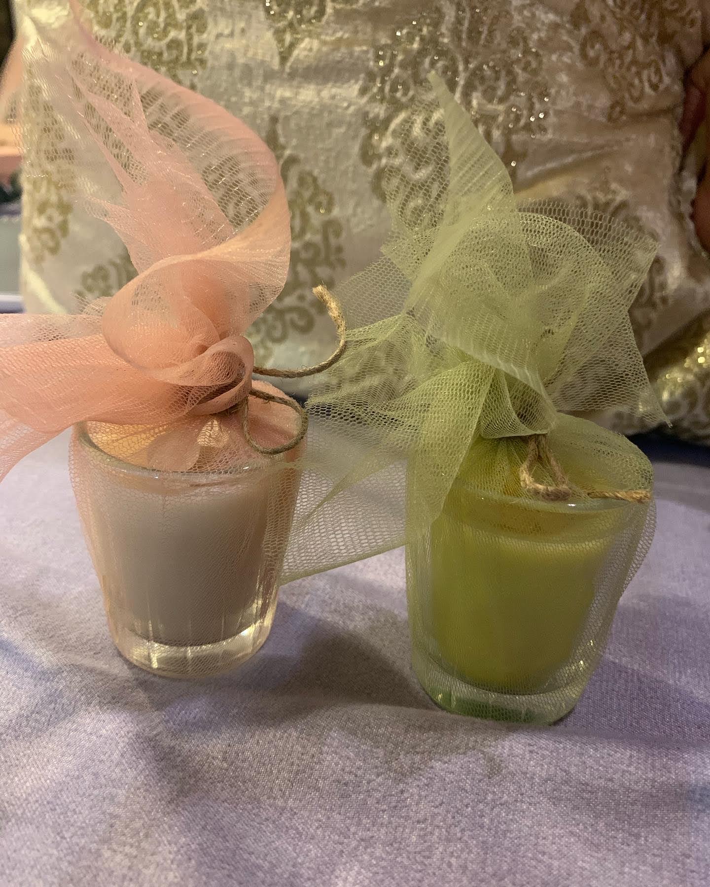 Two tulle-wrapped favour candles in peach and sage tied with twine