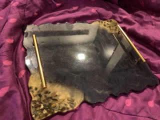 Black resin serving tray with scalloped edge and gold handles