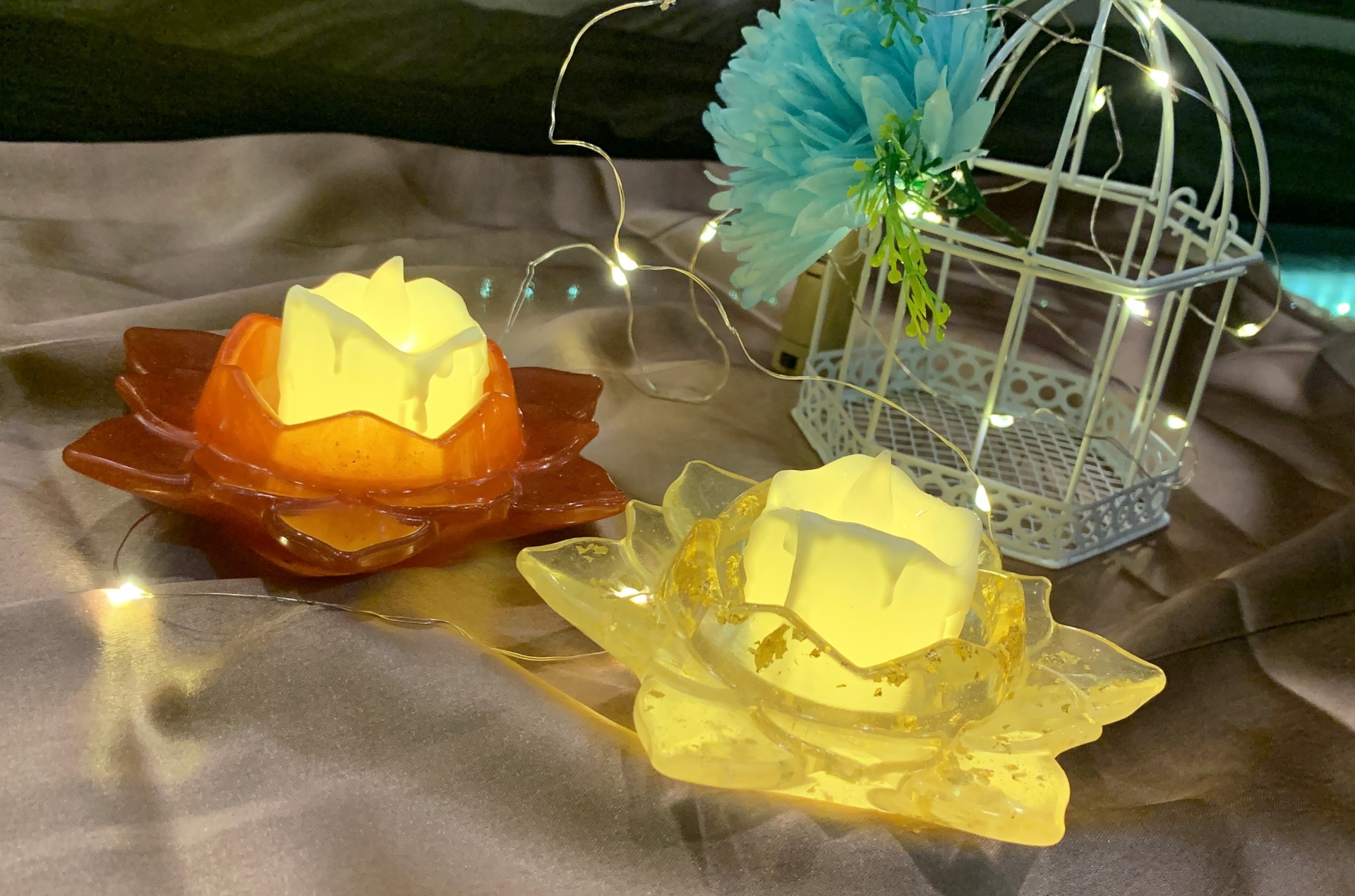 Pair of resin lotus tealight holders in orange and yellow with gold flakes