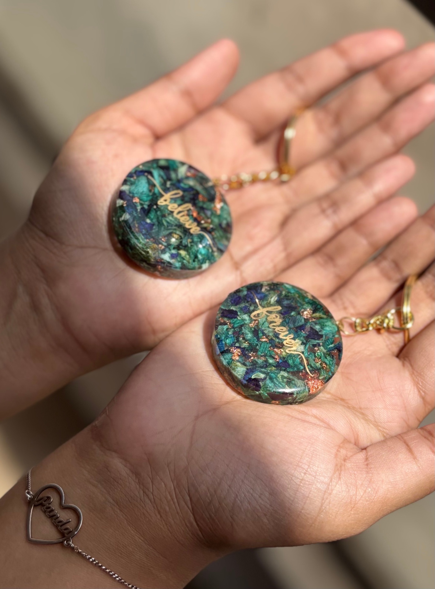 Round resin keychains in emerald with believe and forever in gold script