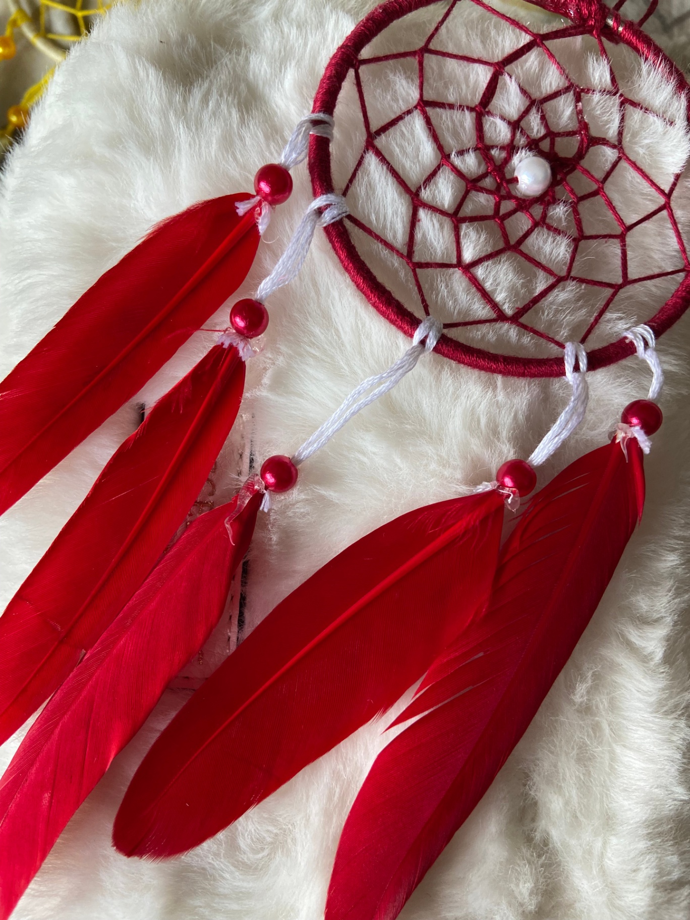 Small red dream catcher with red feathers and pearl bead