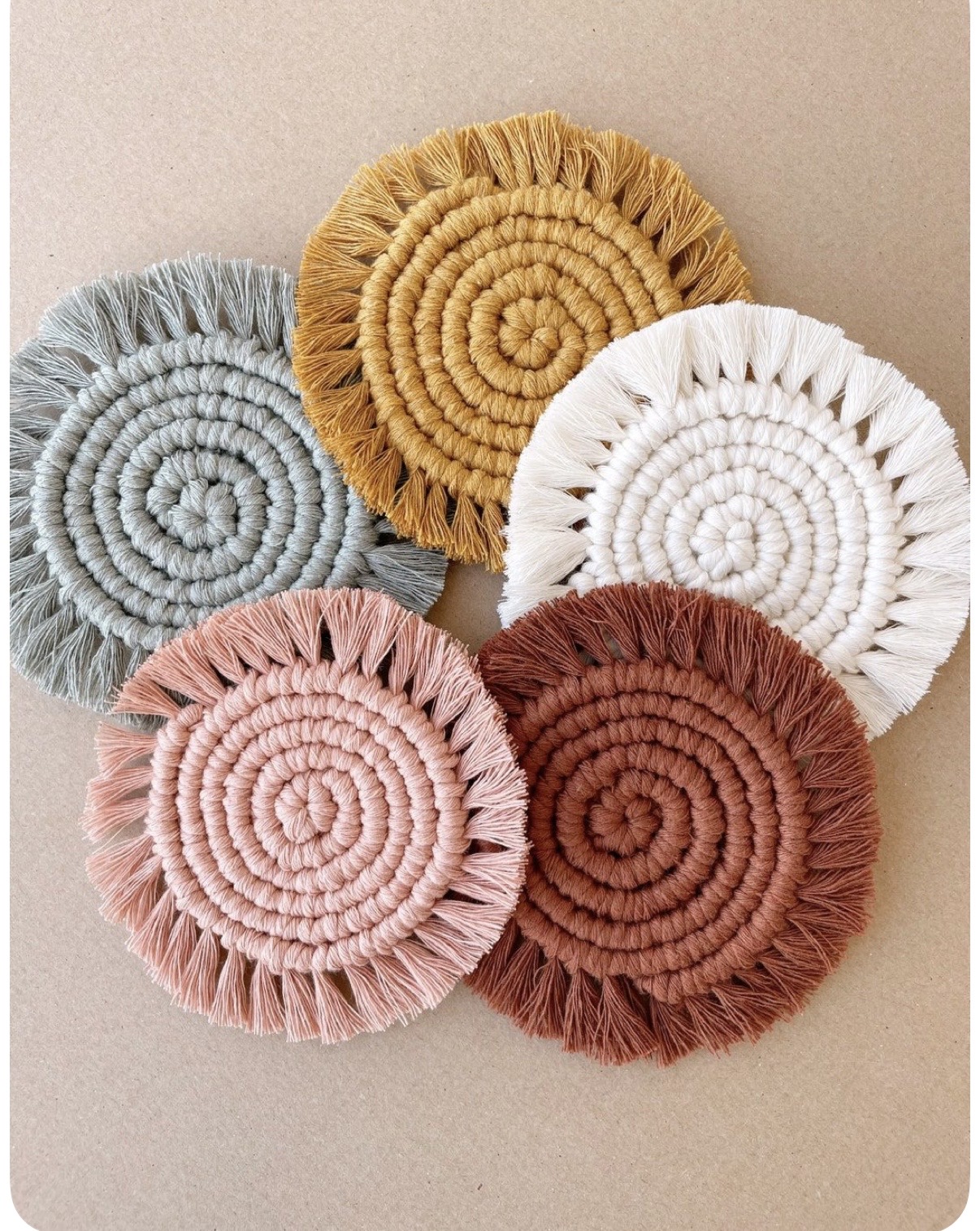 Five fringed macramé coasters in sage, mustard, ivory, blush and rust